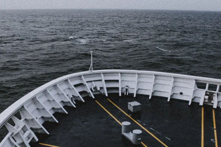 The bow of a large ship cutting through the sea