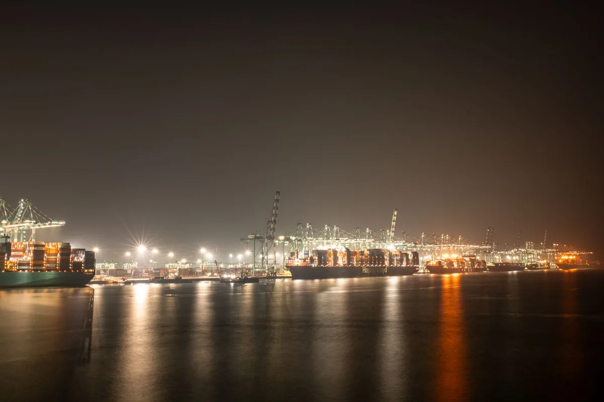 Large gantry cranes loading containers onto a ship at a major port