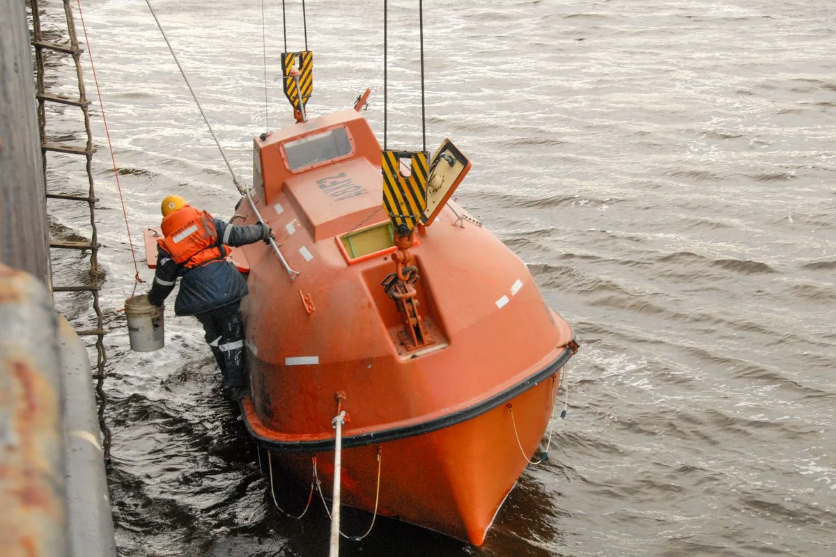 Crew taking part in a lifeboat safety drill at sea.