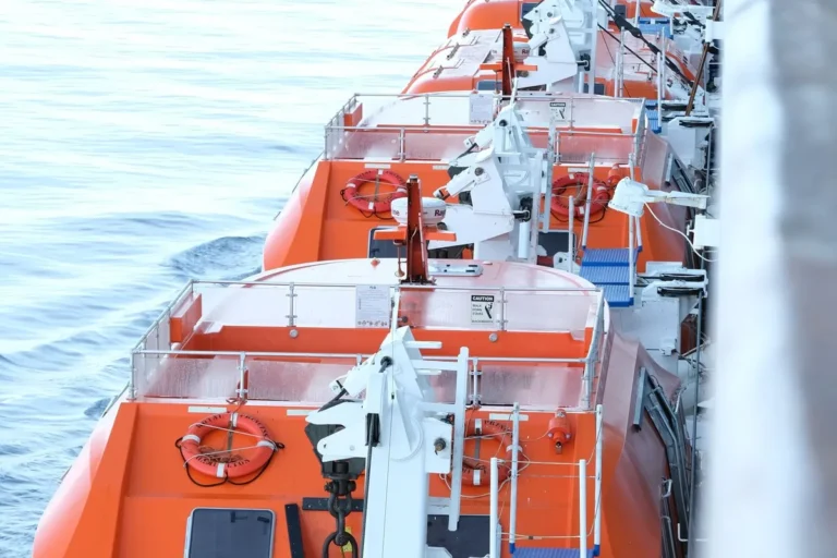 Orange lifeboats mounted on a ship deck under SOLAS rules.